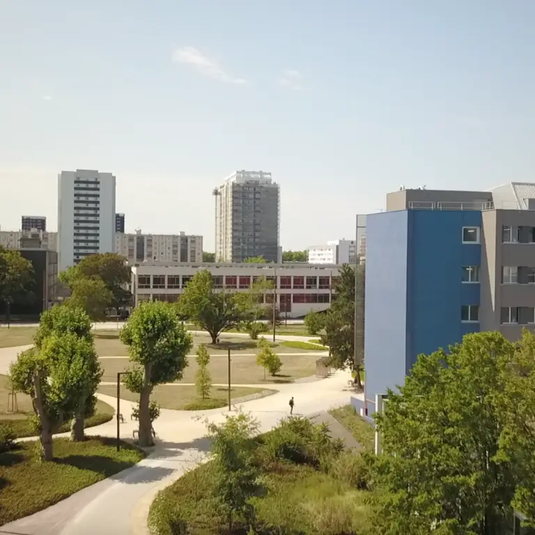 Un campus universitaire composé de bâtiments modernes, d’arbres verdoyants, d’allées spacieuses et, en arrière-plan, d’immeubles de grande hauteur sous un ciel dégagé : un cadre inspirant où la Fondation s’engage à construire l’avenir grâce au mécénat et à des partenariats innovants.