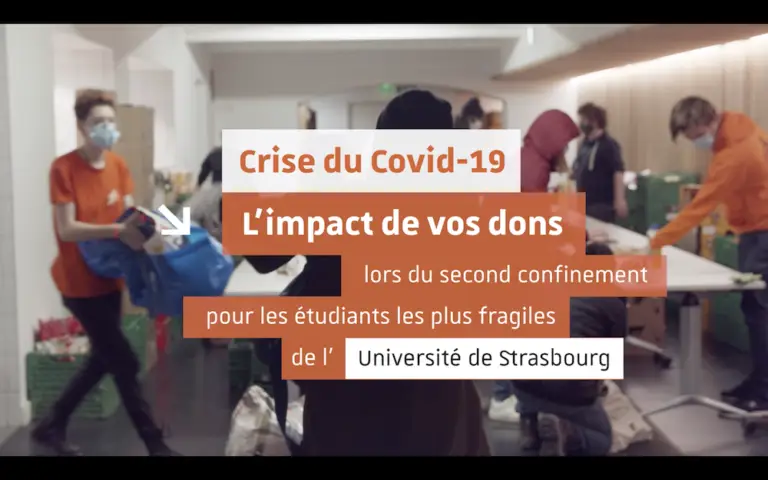 Des personnes portant des masques et des t-shirts orange distribuent des fournitures dans une salle ; un texte en français en surimpression explique comment les dons des étudiants liés à la Covid-19 viennent en aide aux étudiants en situation de précarité de l'Université de Strasbourg pendant le deuxième confinement.