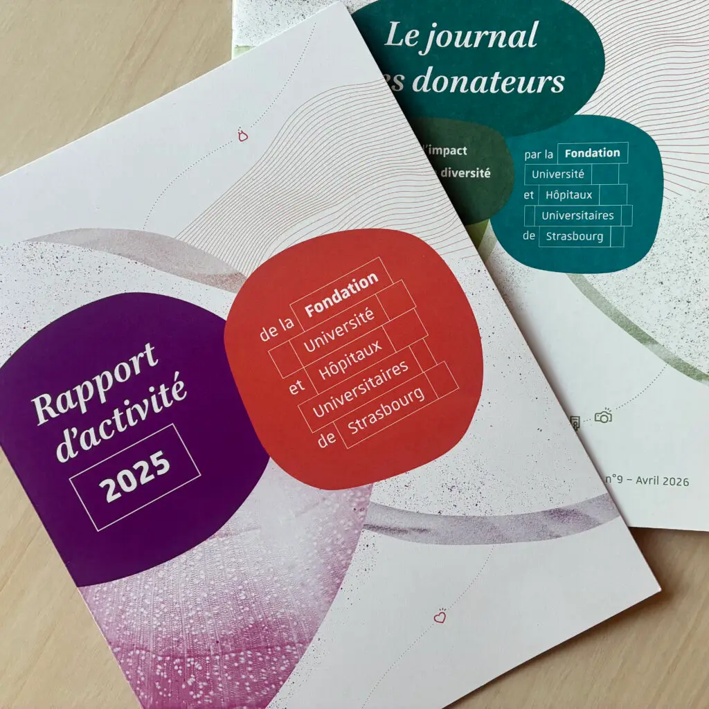 Deux rapports en français émanant de la fondation sont posés l’un sur l’autre sur un bureau clair. Celui du dessus porte le titre « Rapport d’activité 2025 » et est orné de motifs abstraits ; l’autre s’intitule « Le journal des donateurs » et est daté de janvier à avril 2026.