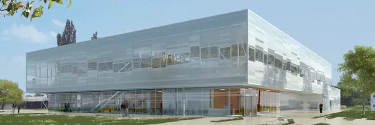 Bâtiment moderne de deux étages, doté d'une façade vitrée, d'escaliers intérieurs apparents et entouré de verdure sous un ciel dégagé, conçu pour incarner la SIMPLICITÉ et l'innovation au service de l'industrie pharmaceutique.